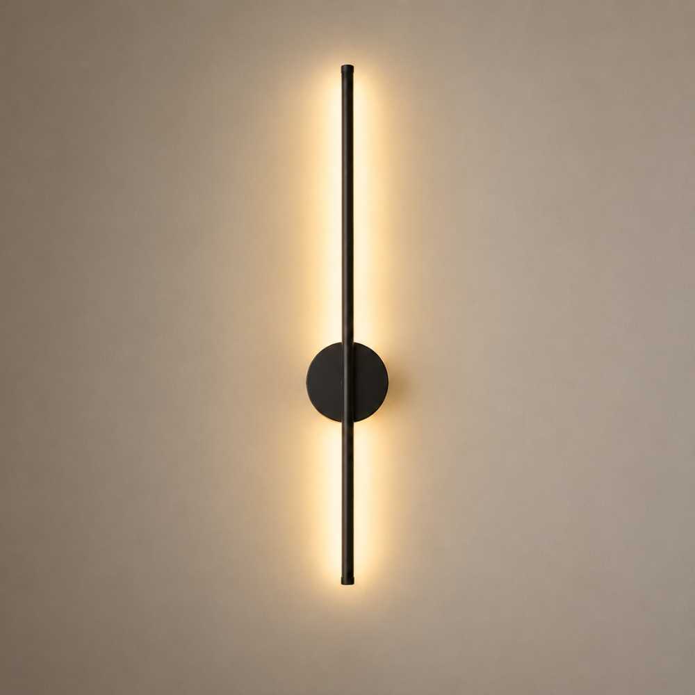 Applique murale LED verticale noire diffusant une lumière chaude indirecte