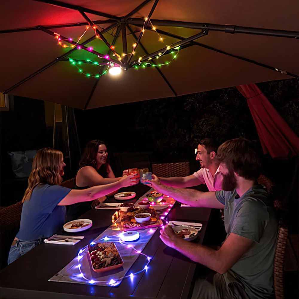 Guirlande lumineuse solaire multicolore installée sous un parasol en terrasse