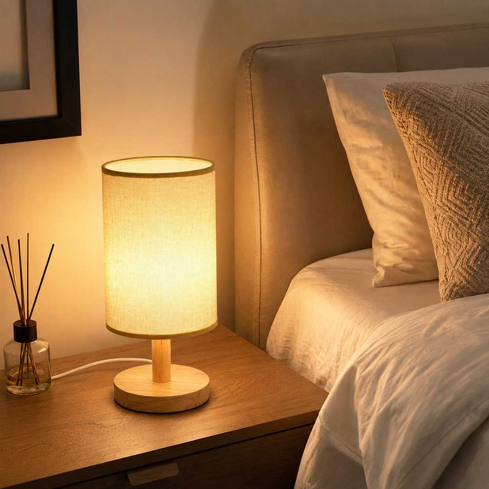 Lampe de chevet en bois et tissu installée sur une table de nuit