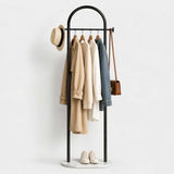 Porte-manteau sur pied en métal noir avec vêtements, chapeau et sac
