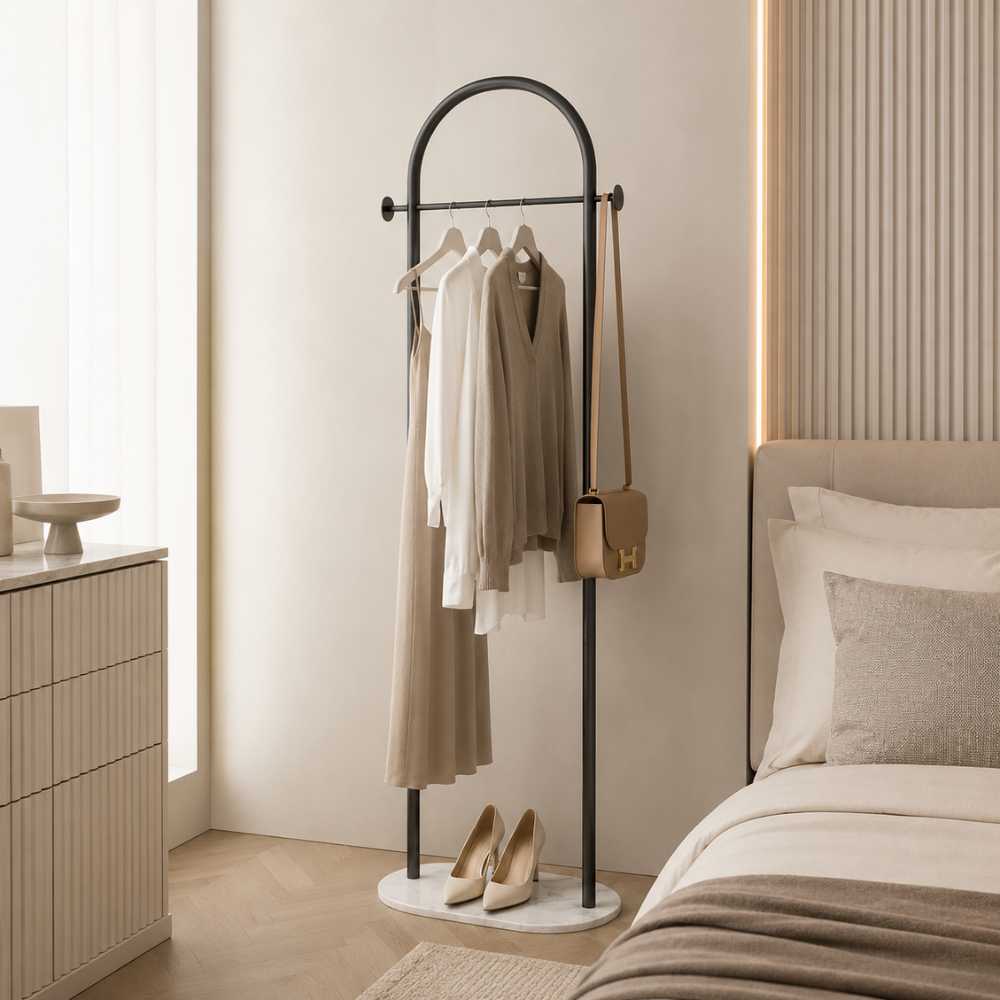 Porte-manteau sur pied noir avec barre pour vêtements dans une chambre